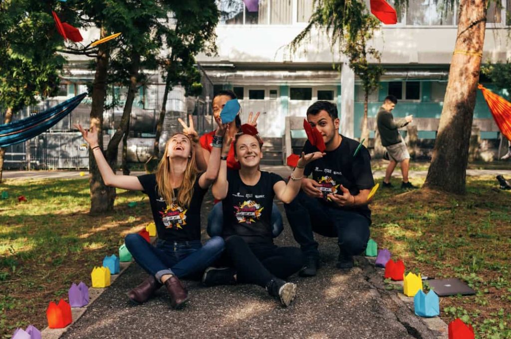 4 church volunteers throwing paper in the air