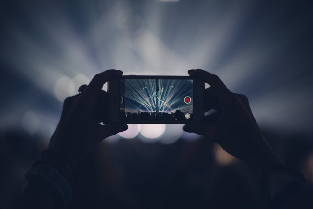 a person recording a benefit concert on a phone