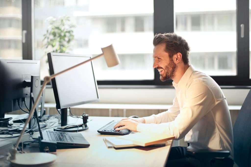 man typing up a nonprofit grant proposal on a computer