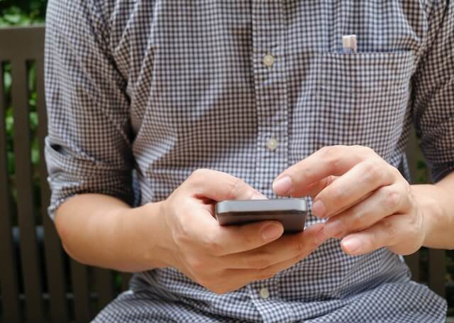 A man makes a donation via text message on his smartphone.