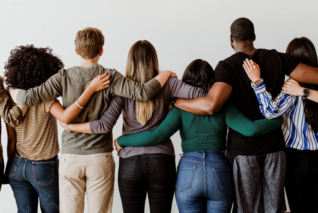 Rearview of six people with their arms around each other