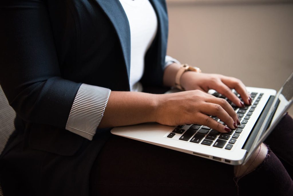 woman typing up a nonprofit grant proposal on a laptop