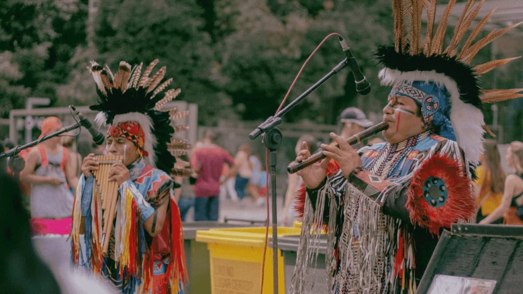 Two American Indians playing woodwind instruments